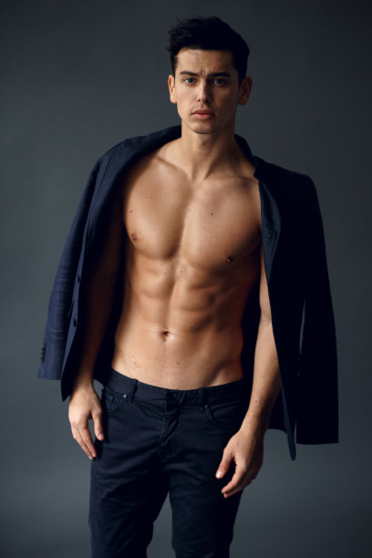 正面的观点，一个运动员，健康的人和优雅的西装，看着相机，孤立在一个灰色的背景。图片下载