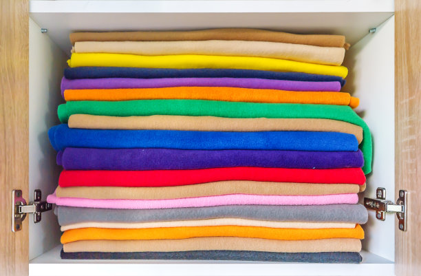 一套色彩缤纷的浴室毛巾，摆放完美。新颜色的毛巾堆在架子上图片下载