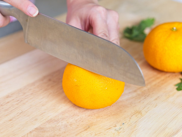 切橘子，放在木砧板上图片下载