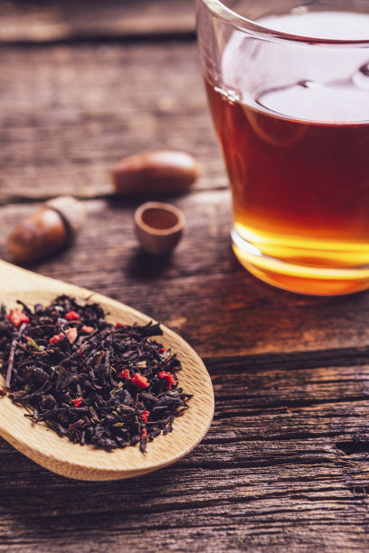 玻璃杯里放着茶和木勺浆果花草茶图片下载
