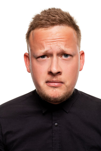 近距离的肖像一个自信，金发，英俊的年轻人穿着黑色衬衫，孤立在白色的背景图片下载