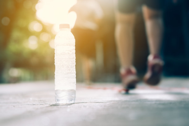 为运动员运动后在地上饮用水瓶，为运动员运动前热身图片下载