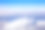 白雪皑皑的山峰上，白云悬在蓝天上。从飞机窗户拍摄的航拍照片。图片下载