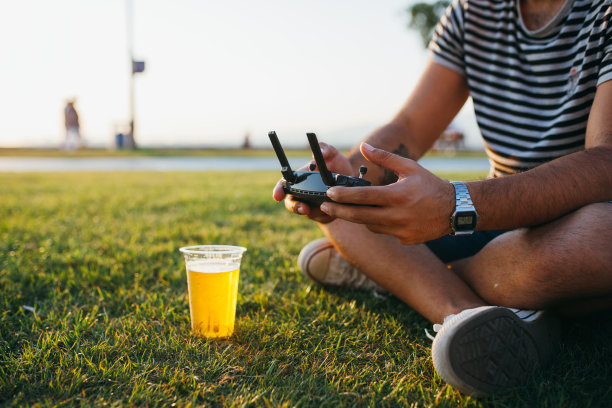 飞行员在日落时使用无人机遥控图片下载