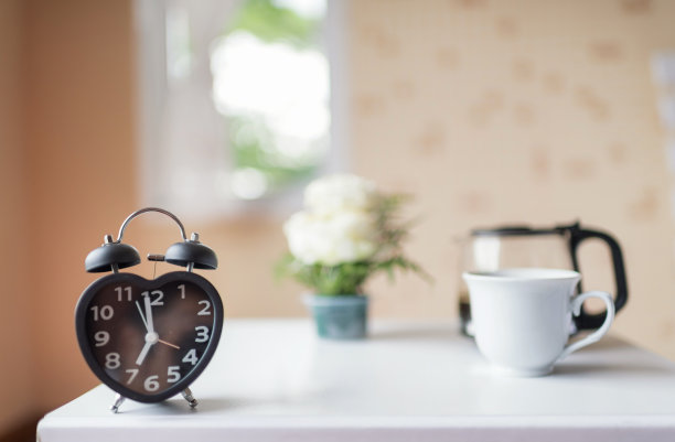 闹钟在家里的床边。早晨时间背景概念图片下载