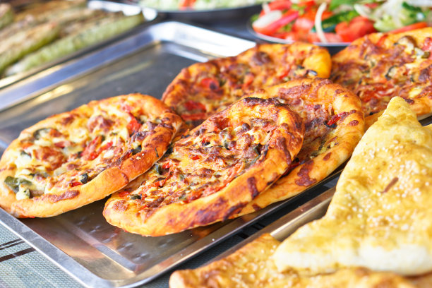 准备好的披萨，有肉和香肠，还有蔬菜。暑假和大自然中的食物。库存图片图片下载