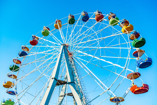五颜六色的游乐场摩天轮在蓝天的背景下图片下载