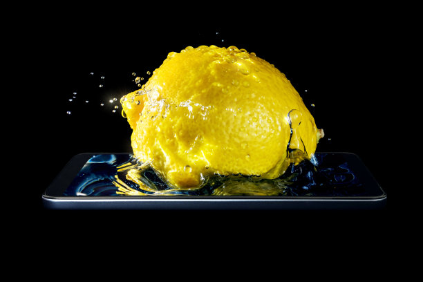 这是一个概念创意的3D立体照片，一个柠檬的特写在水花和阳光落入水中，在一个孤立的黑色背景智能手机。图片下载
