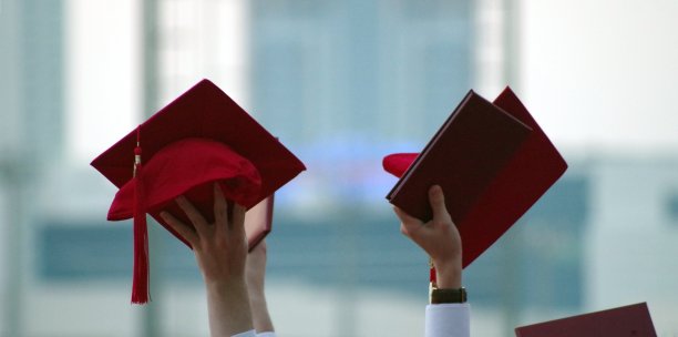 应届毕业生戴着他们的头在空中庆祝。毕业的概念。毕业帽。图片下载