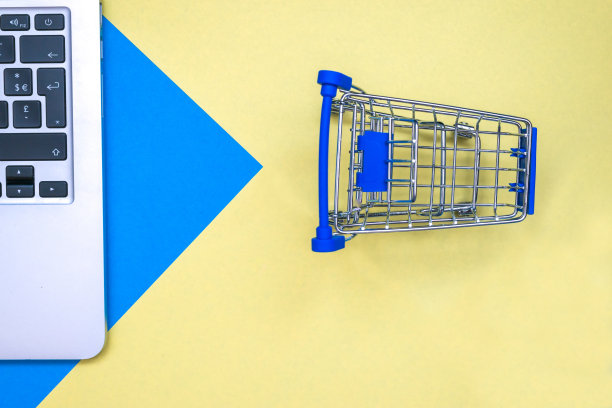 平铺设计，配有笔记本电脑和手推车。蓝色和黄色背景图片下载