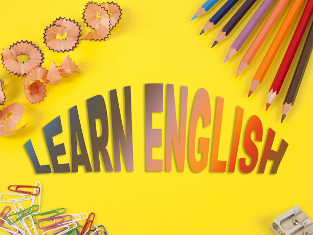 一些不同颜色的彩色铅笔和一个卷笔刀和铅笔屑在黄色的背景。单词学习英语图片下载