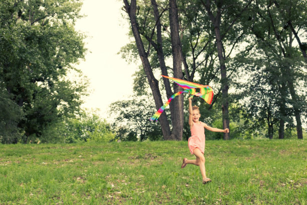 无忧无虑的女孩在春天放风筝。图片下载