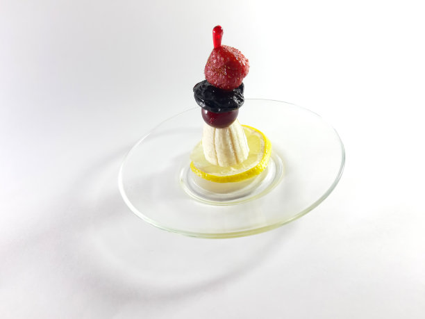 美味的菜。健康食品。把素食放在透明的盘子里。浆果和水果。柠檬和樱桃当点心。现代设计照片。用香蕉、草莓和樱桃做成的点心。图片下载