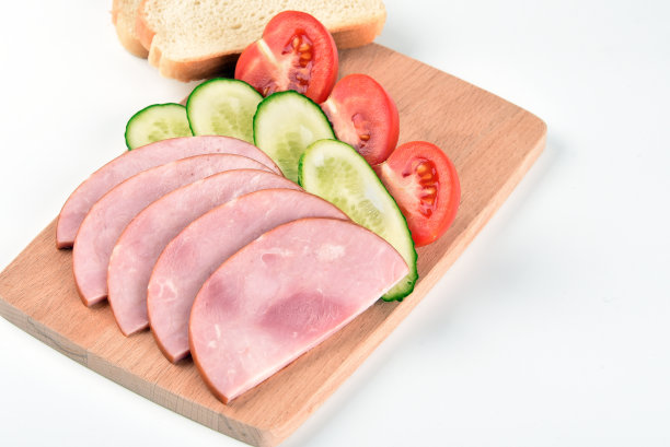 切好的火腿放在砧板上，以白色背景隔开图片下载