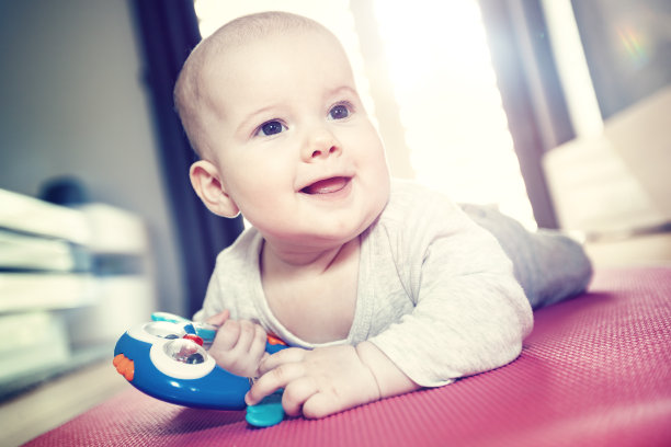 一个快乐的微笑的孩子躺在他的肚子上图片下载