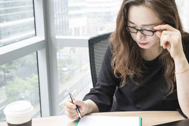 这个办公室女职员正专注于工作。素材图片