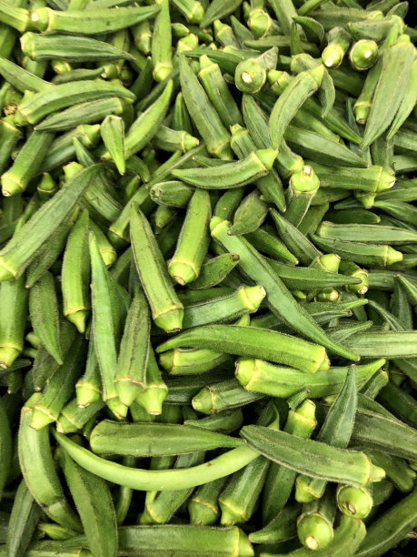 绿色的秋葵/赭石/赭石种子豆荚印度女士的手指/女士的手指堆在街头市场的绿色杂货店，水果和蔬菜超市的柜台与印度烹饪女士的手指，富含果聚糖和纤维图片下载