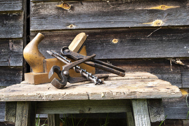 古董手工具，刨钳和钻头。褐色的旧木板。本空间图片下载