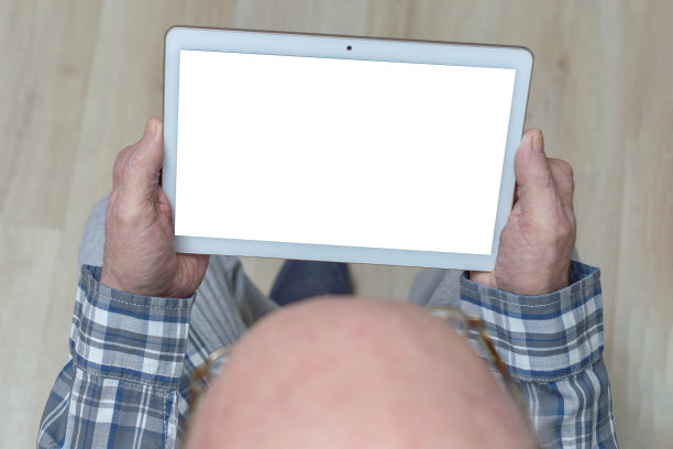 老人拿着一个平板电脑。副本的空间。图片下载