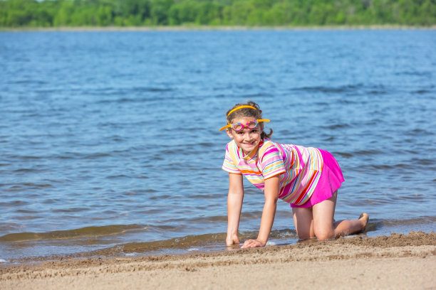 夏天的一天，小女孩在海滩上玩耍图片下载