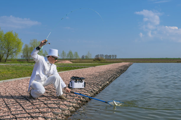 精致的钓鱼。在鳟鱼区，身着白衣的渔夫用纺丝棒捕鱼图片下载
