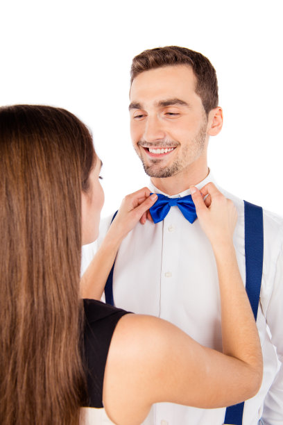 特写照片的一个女孩绑一个蓝色的蝴蝶结给她的男朋友图片下载