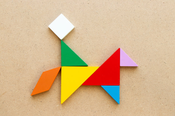 彩色七巧板拼图以人骑马的形状为木头背景图片下载