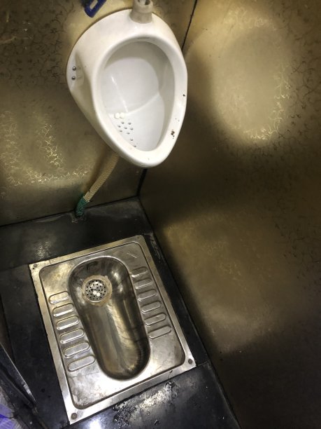 印度卧铺巴士上的传统印度地板厕所和小便池照片，不卫生，不锈钢地板厕所，陶瓷小便池图片下载