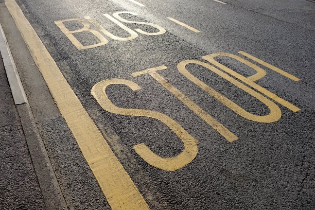 晨曦中，黄色的“公交车站”路标图片下载