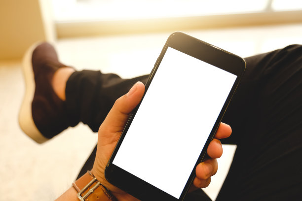 一个男人用手机的特写，在咖啡店里发送信息。在日光浴。黑屏手机，短信，视频通话，图片下载