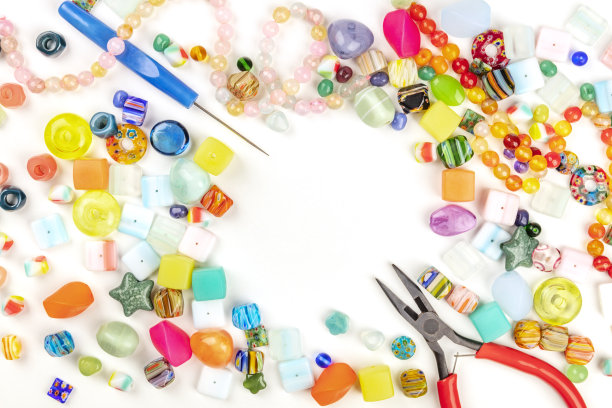 许多不同的珠子与工具制作珠宝，从顶部拍摄的白色背景与文字的地方图片下载