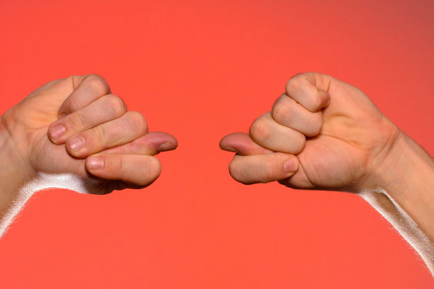 男子的手与无花果标志特写是孤立在一个红色的背景图片下载