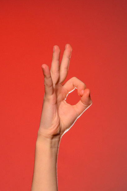 人的手表示ok，象征积极的，孤立在红色背景上。图片下载