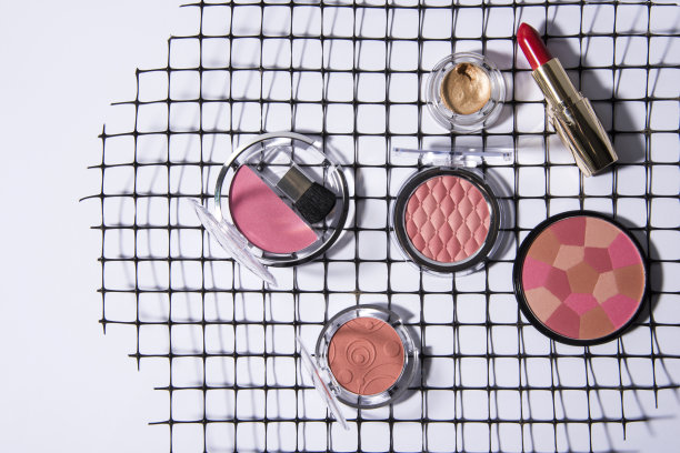 化妆品放在不同的平台上，比如纸盒，泡沫塑料和塑料网。图片下载