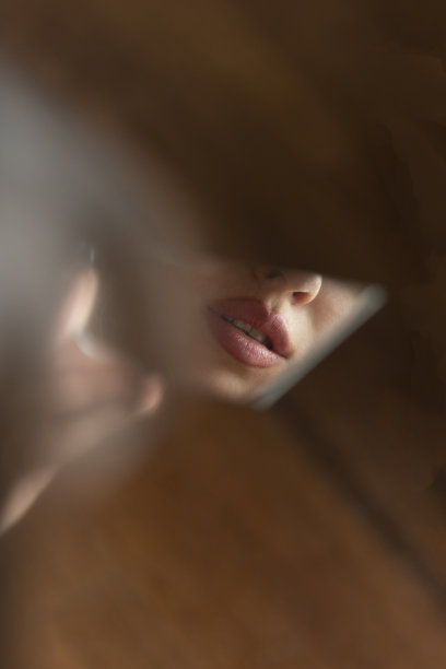 美丽女人的嘴唇对着破碎的镜子图片下载