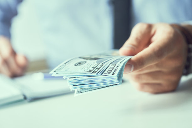 一个人给钱的时候手里拿着现金。货币信贷的概念。健美的图片。图片下载
