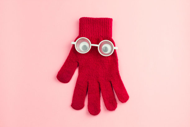 红色的手套和白色的眼镜，在粉红色的背景图片下载
