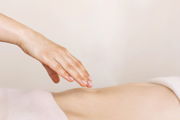 在水疗中心或医疗中心接受腹部按摩的年轻女子。图片下载