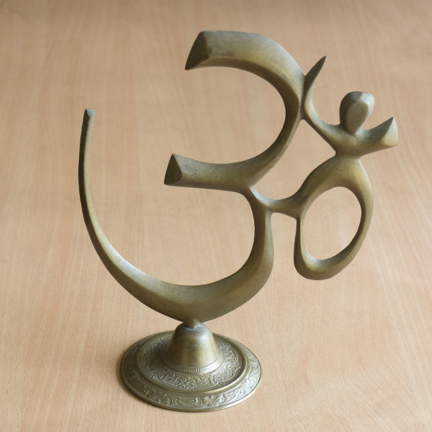 木背景上黄色金属的Om符号图片下载