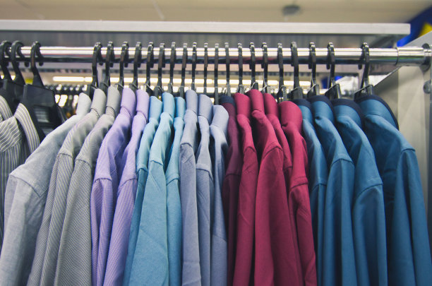 为男士选择多彩的衣服挂在衣架上，以商场为卖点图片下载