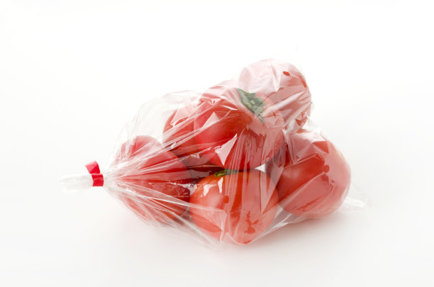 熟透的红番茄装在塑料袋里，白色背景图片下载
