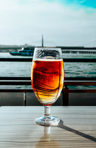 阳光下的一杯啤酒，博斯普鲁斯港咖啡馆，背景是游艇。图片下载