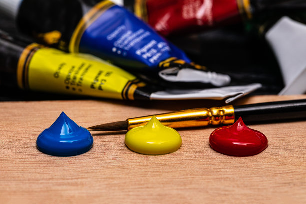 这是一个由三位艺术家的丙烯颜料制成的大图，以红色、黄色和蓝色为原色，在背景中添加了几桶颜料和一个艺术家的画笔。前景提供了足够的空间为文案和点点，形状像巧克力ch图片下载