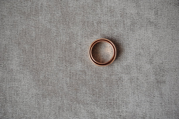 经典的结婚戒指躺在织物表面有纹理。婚戒和文本模板。特写镜头图片下载