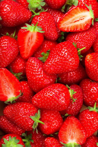 厨房桌上的木碗里放着洗过汁的草莓。——图片图片下载