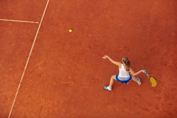 空中拍摄的一个女子网球运动员在一个球场上的比赛。年轻女子在打网球。高角度的观点。图片下载