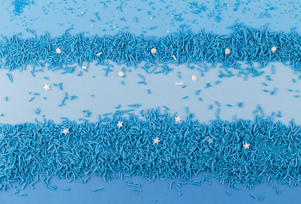 用蓝色的蛋糕点缀和糖晶体点缀背景-顶视图图片下载