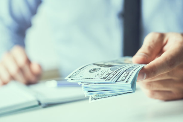 一个人给钱的时候手里拿着现金。货币信贷的概念。健美的图片。图片下载