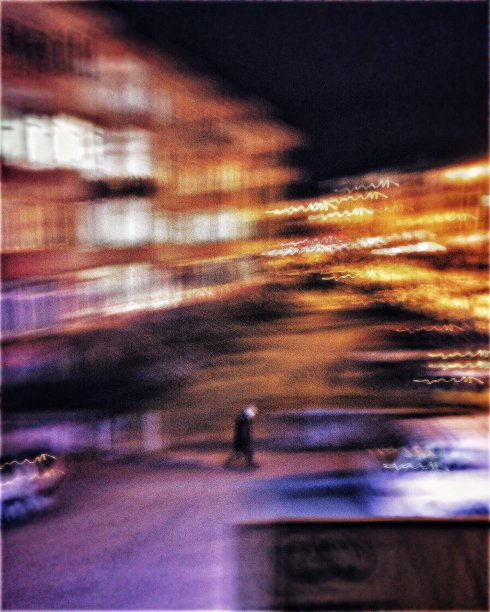 一个人在晚上走在街上的模糊运动视图图片下载