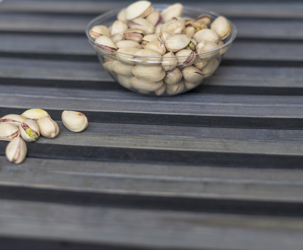 健康的食物背景图片近距离开心果。俯视图果仁开心果在杯盘上图片下载